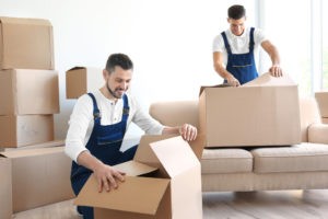 delivery men with moving boxes room new home