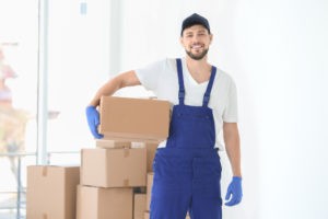 house moving concept man holding cardboard box indoor