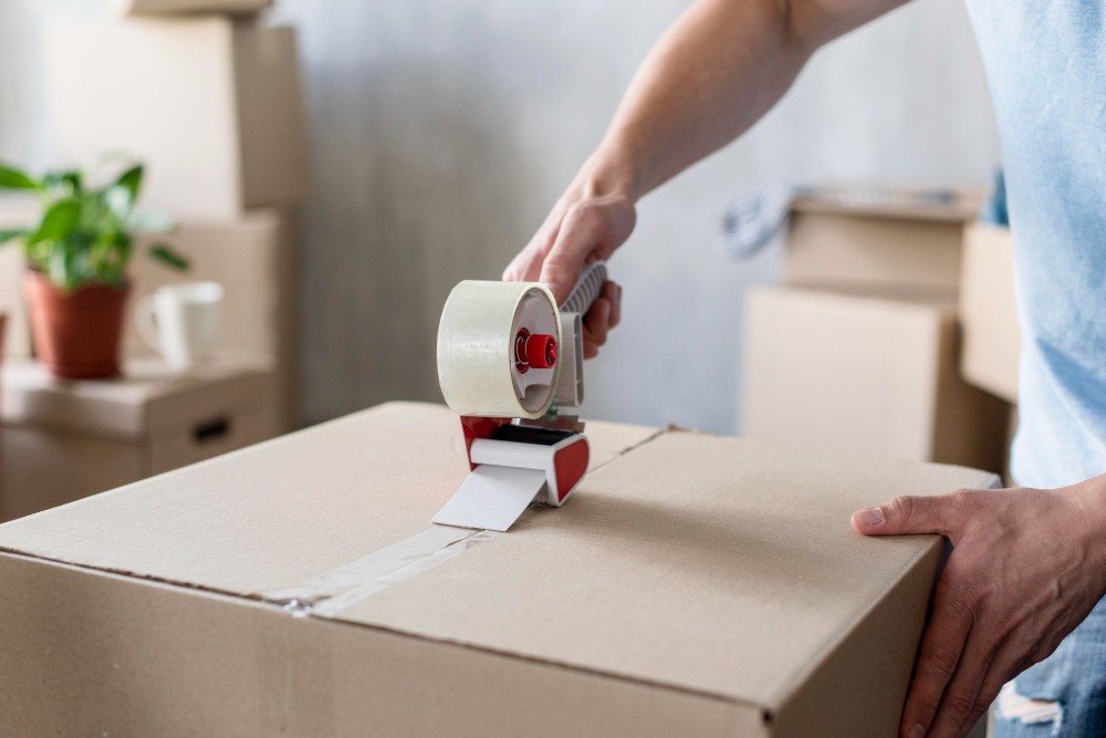 man using scotch tape box ready moving out