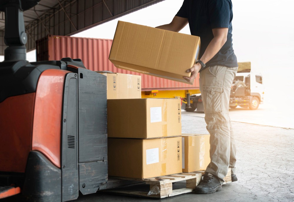 shipment boxes warhouse worker lifting cardboard boxes stacking pallet
